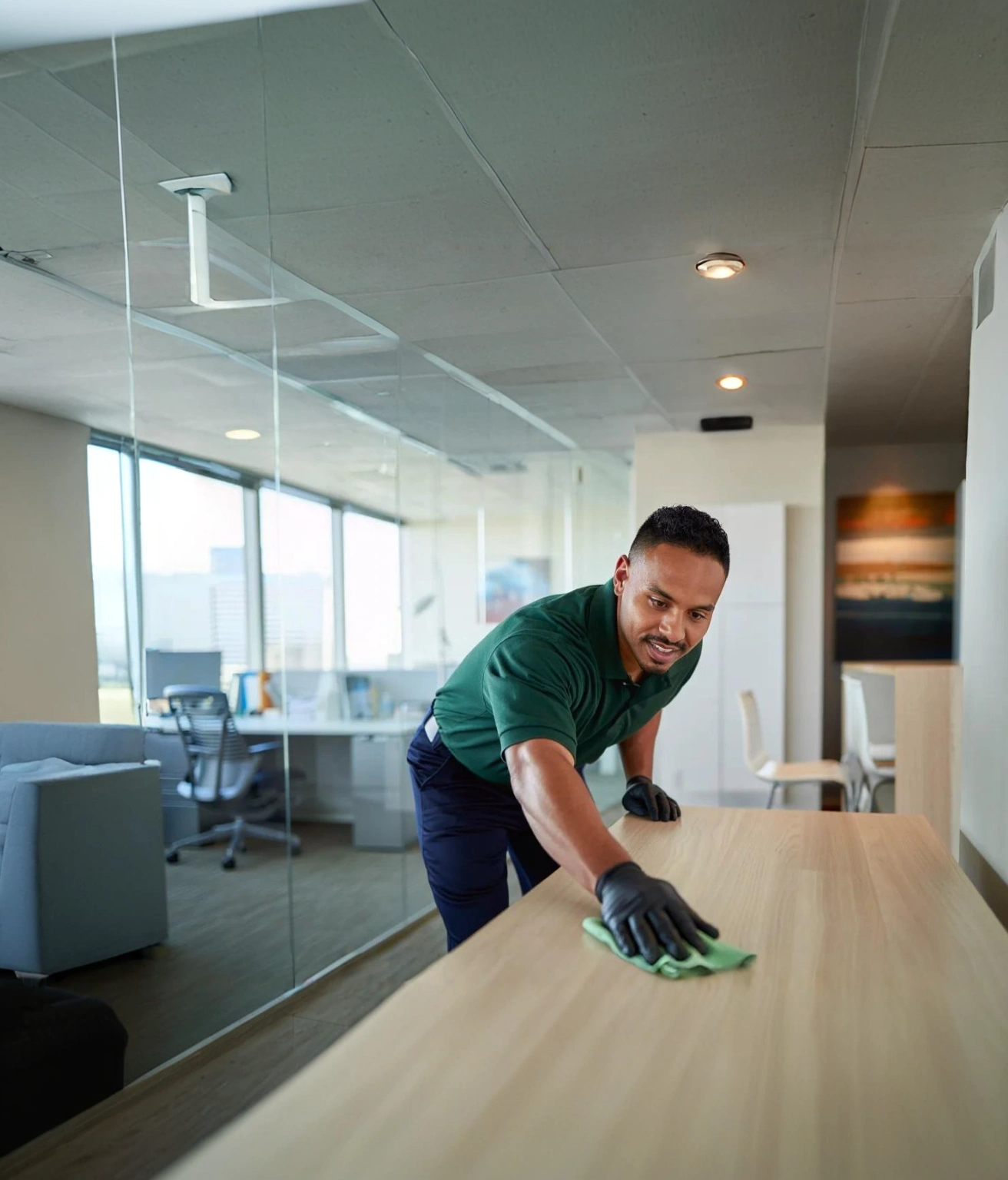 Janitor wiping conference table in view